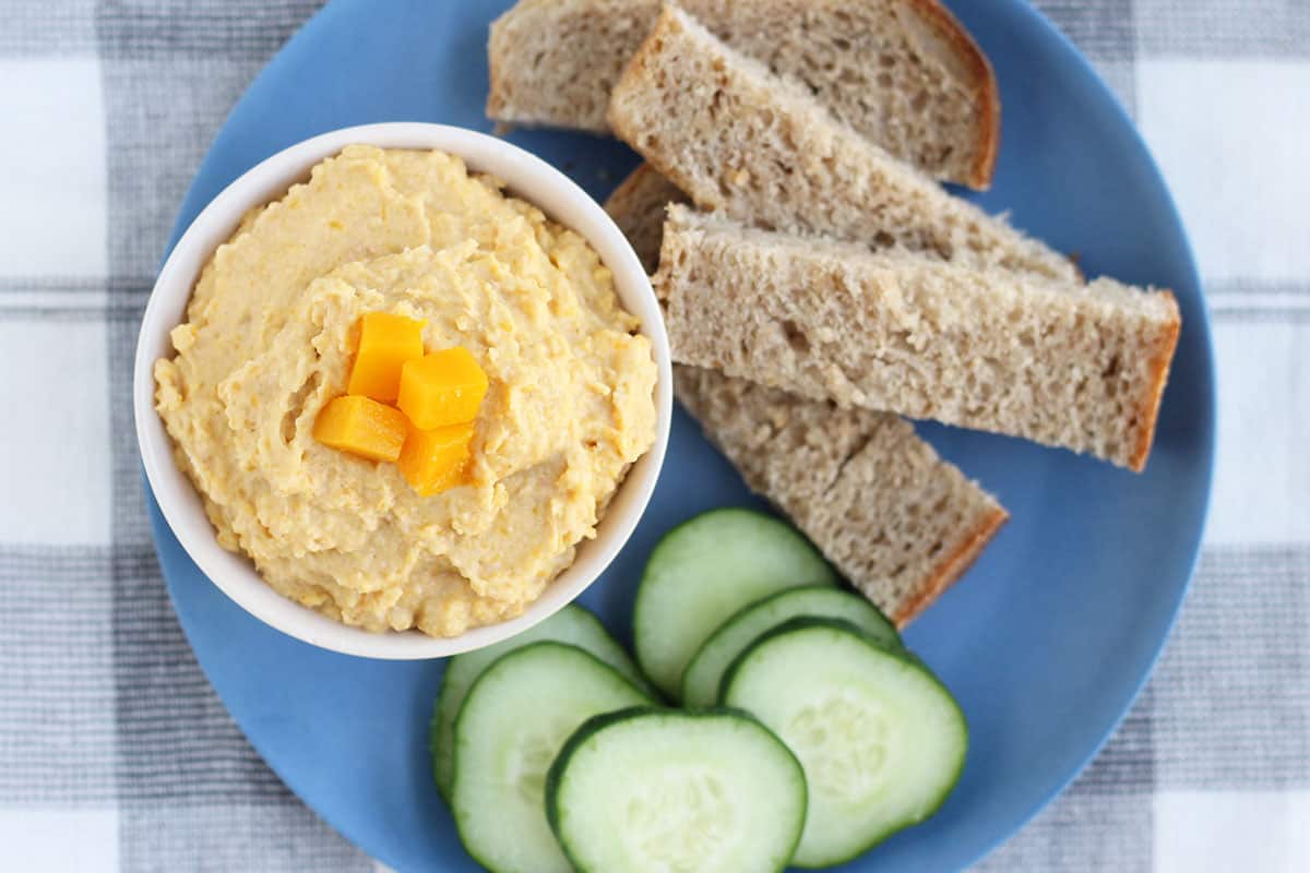 butternut squash hummus in white bowl with dippers.