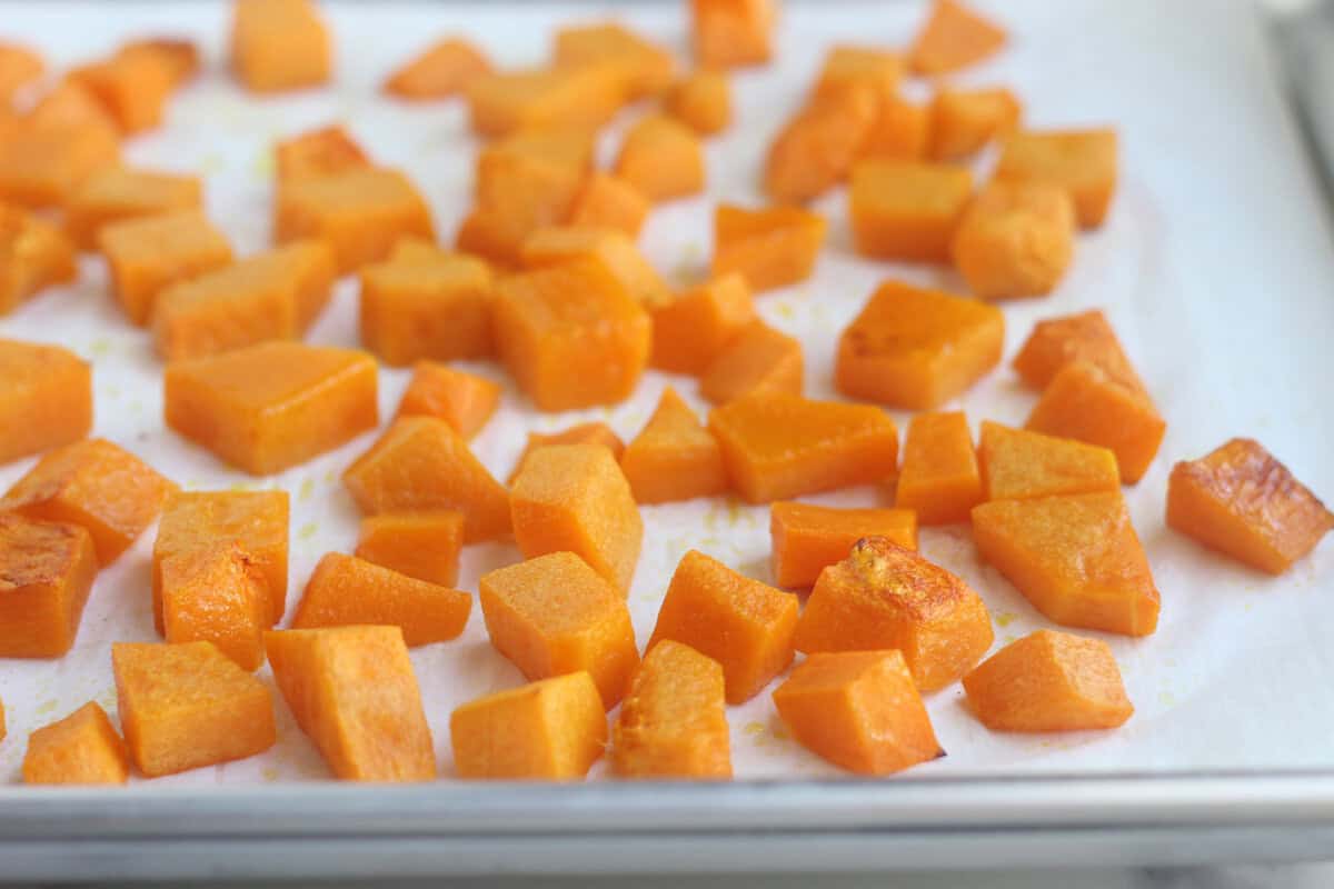 Butternut squash cubes on baking sheet.