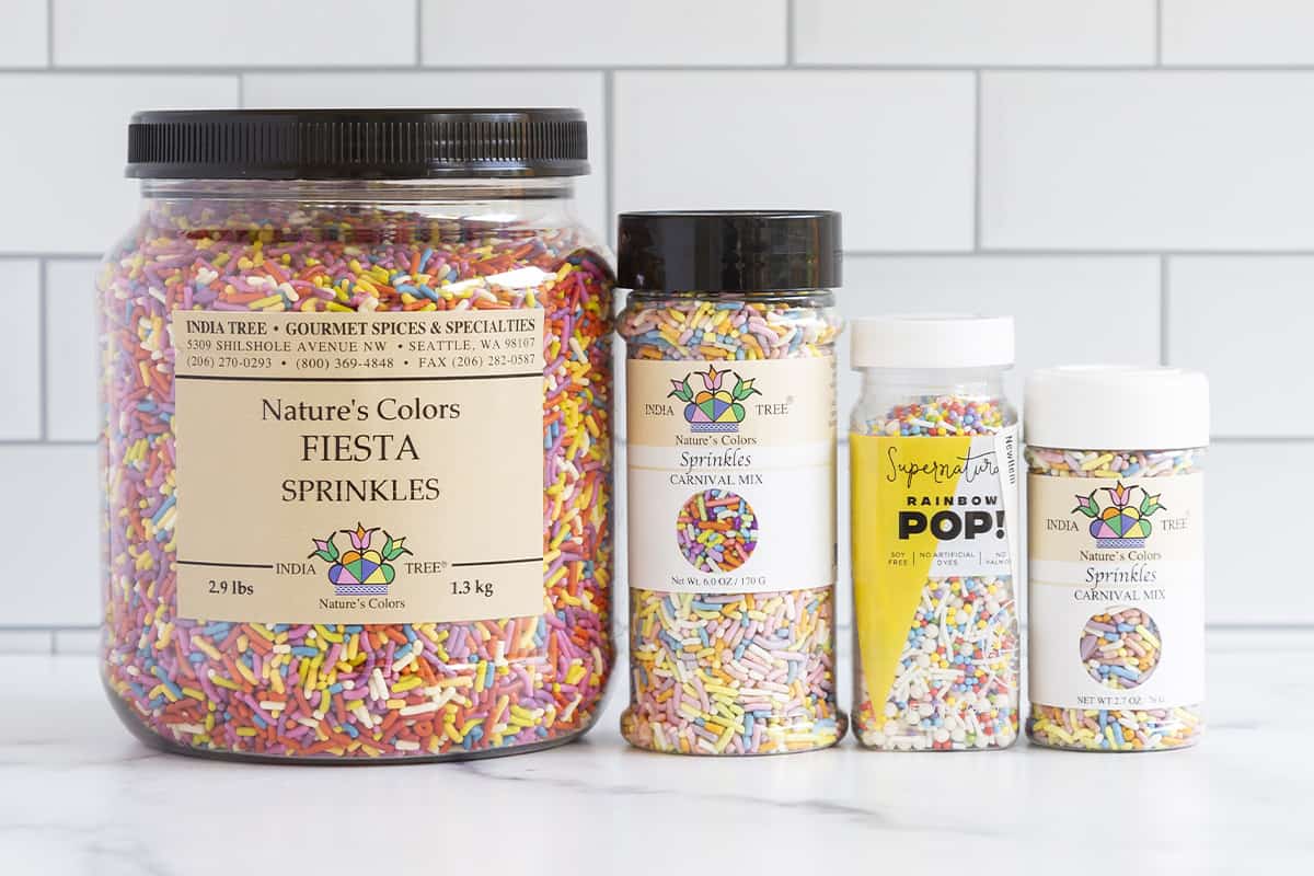 Natural sprinkles in four containers on countertop.