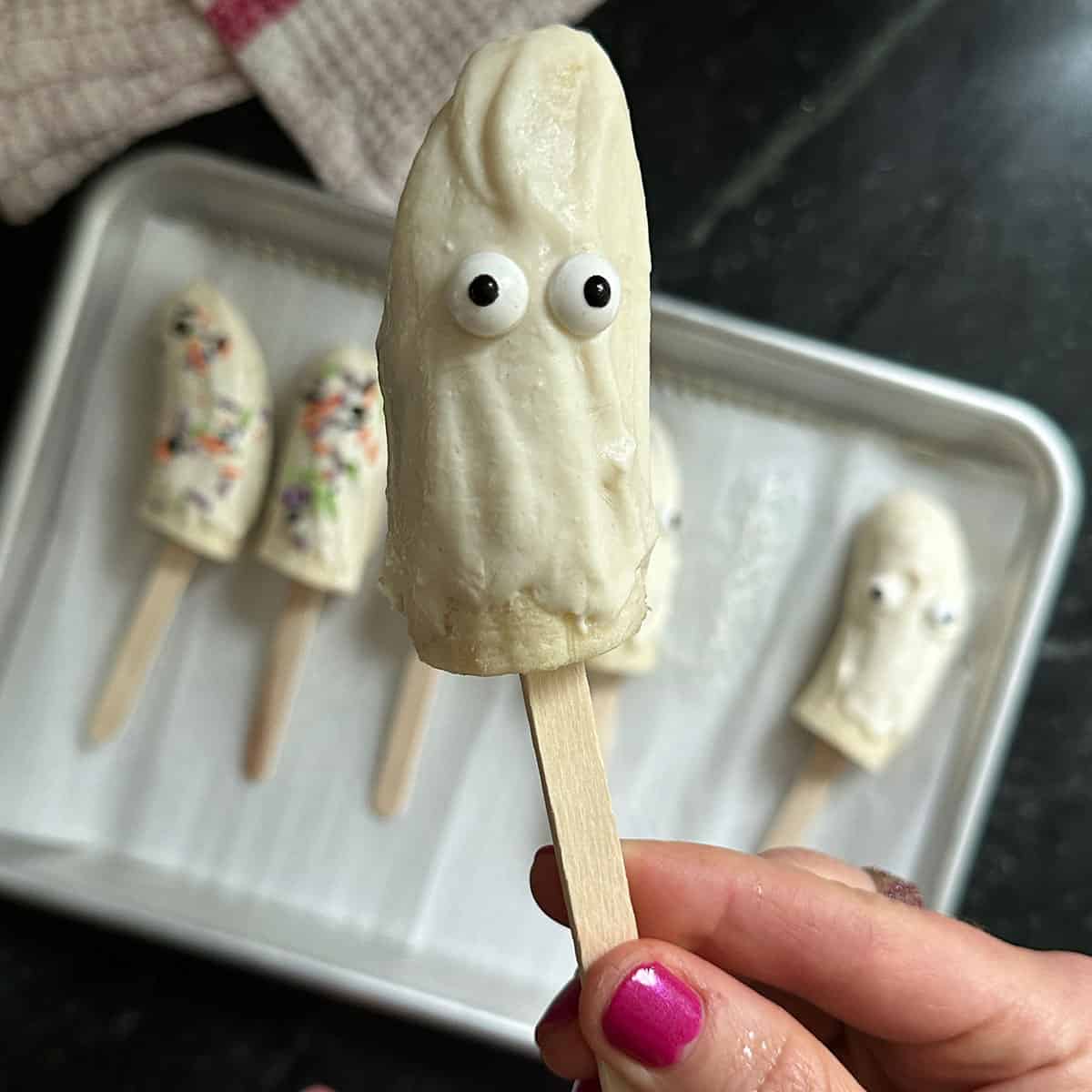 banana pops with candy eyes with hand.