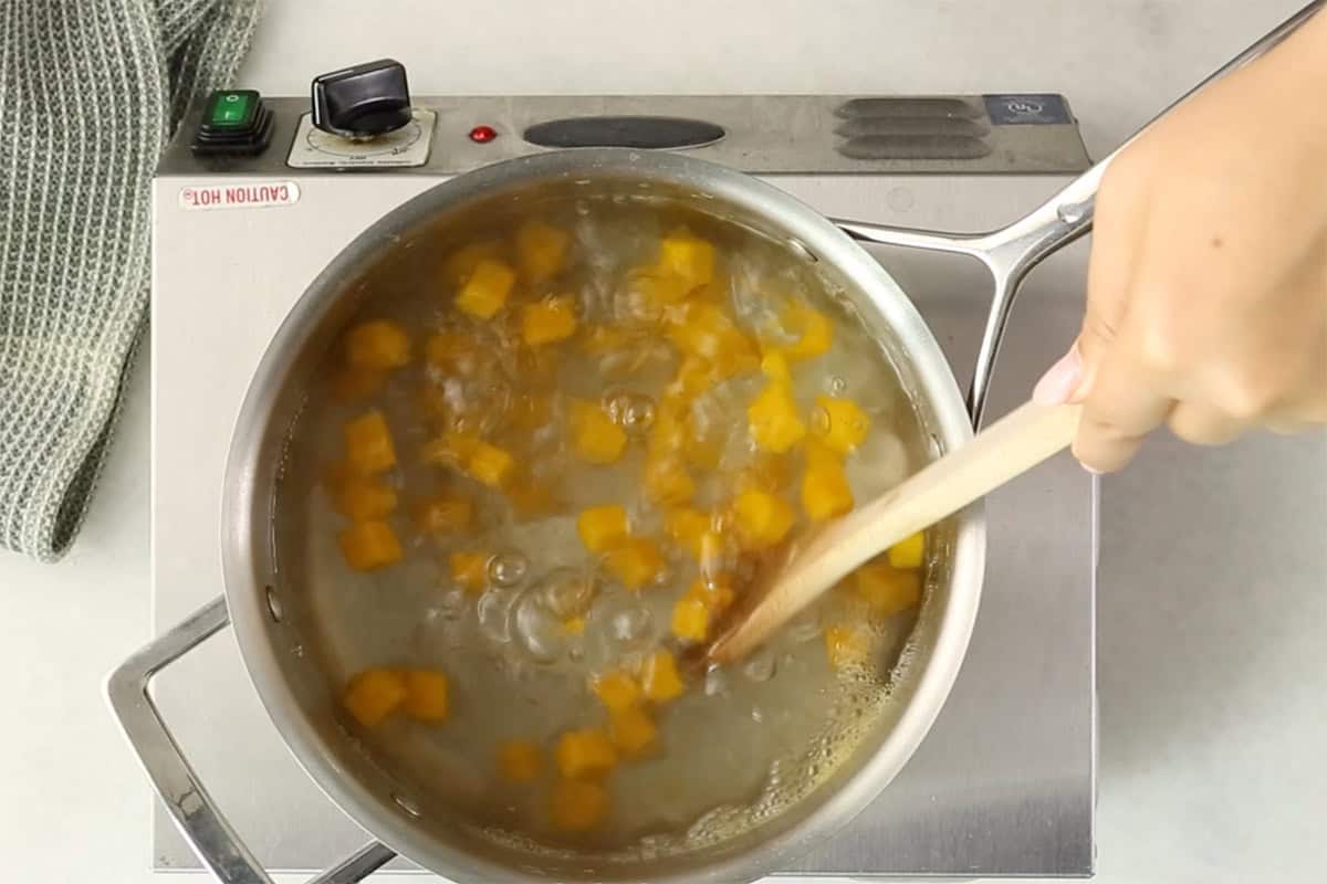 Butternut squash in pot of water.