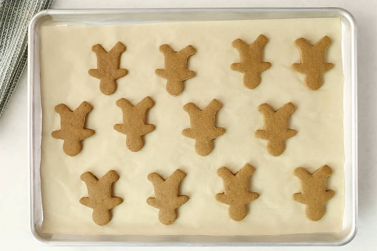 cut out gingerbread cookies on parchment lined pan.