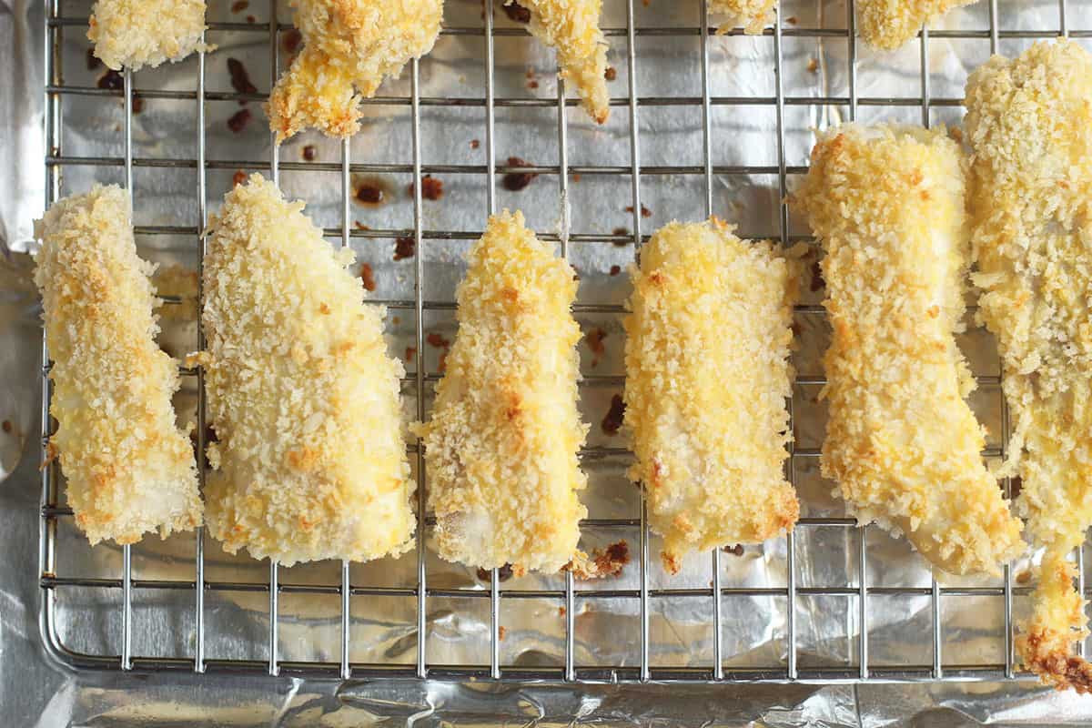fish strips coated in breadcrumbs on tray.
