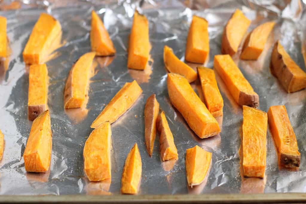 slices of sweet potato on foil lined baking sheet.