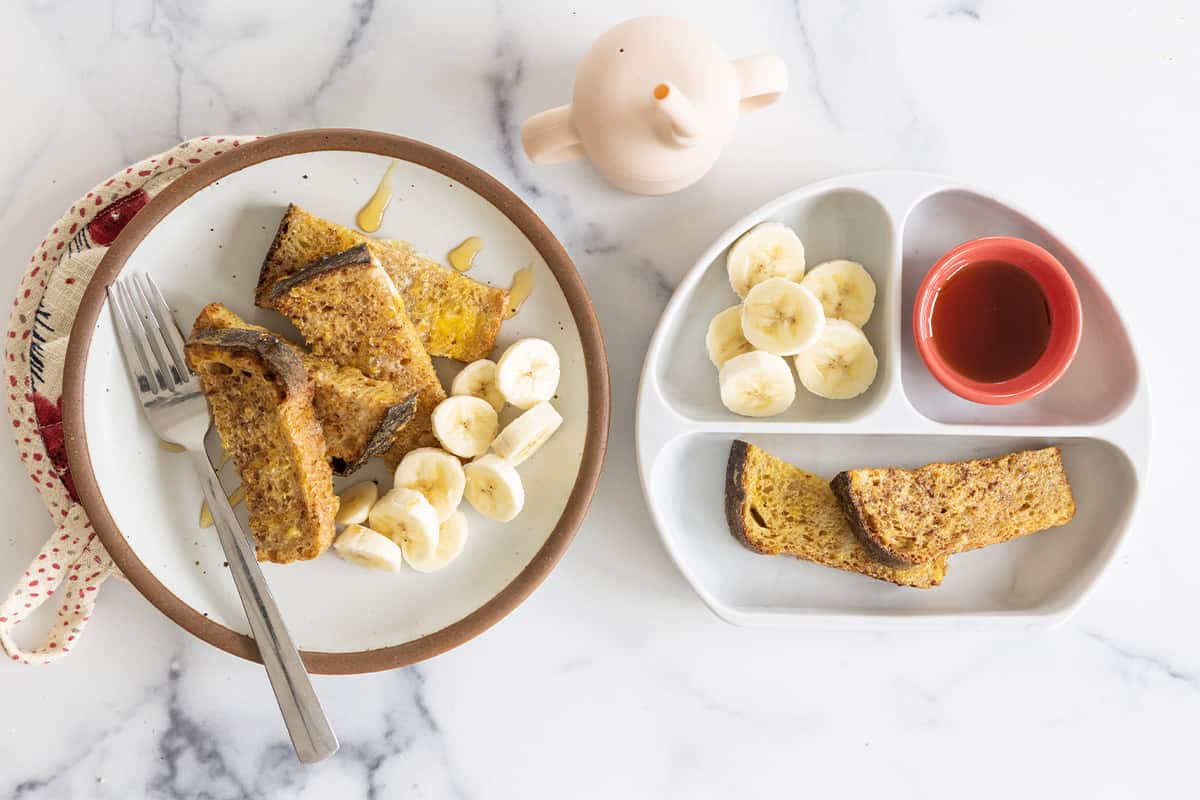 Air Fryer French Toast and adult and kids plates with bananas and syrup.