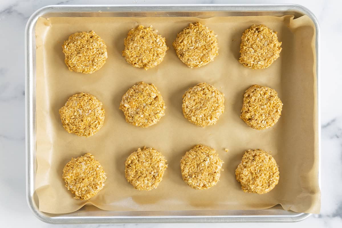 Flattened sweet potato cookies on a baking sheet.