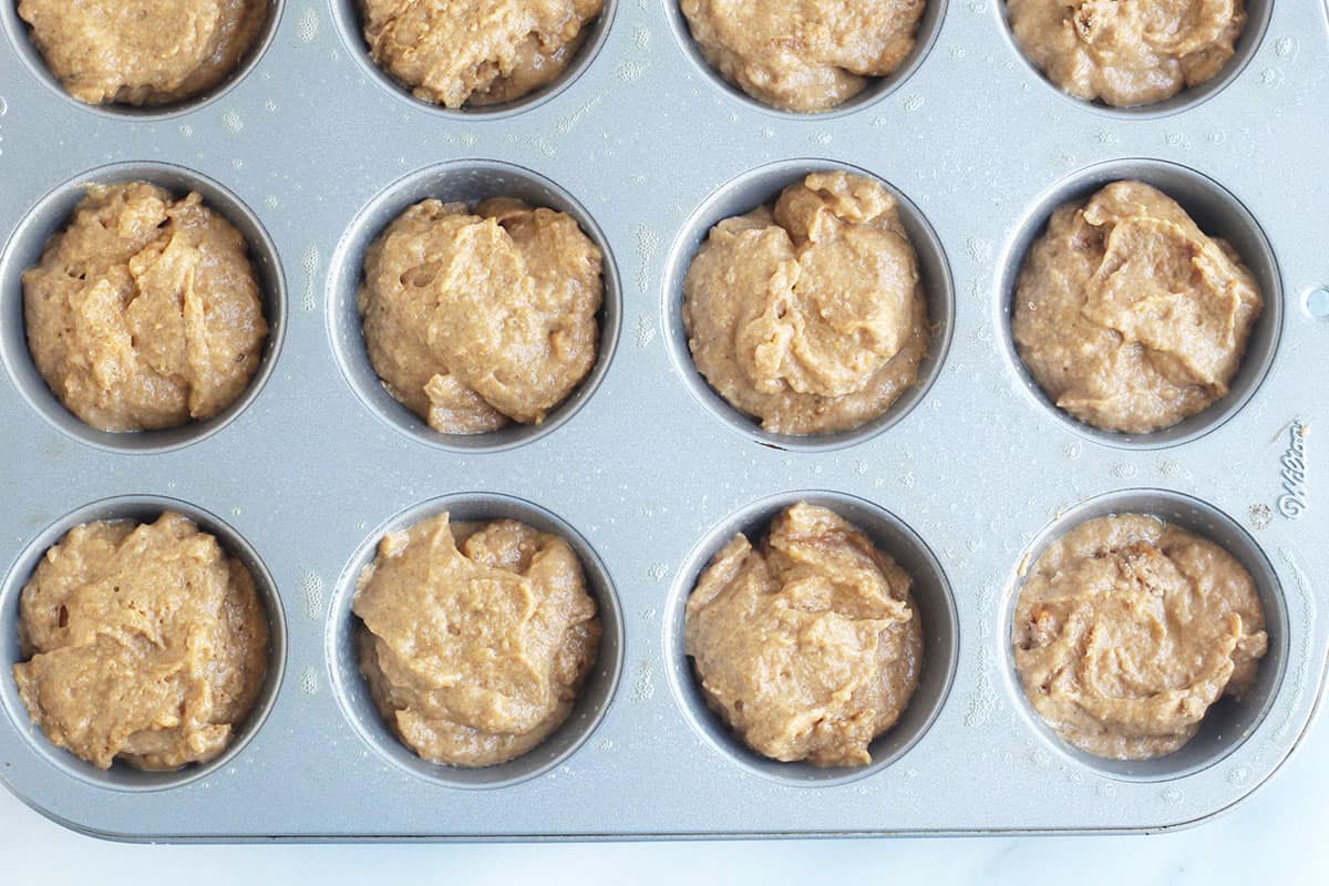 sweet potato muffin batter in muffin pan.