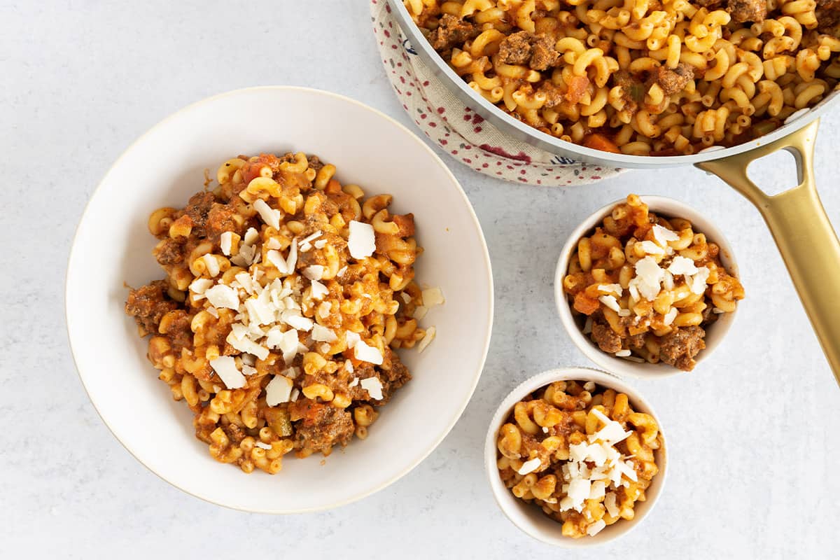 Ground beef pasta in three bowls and pot.