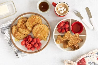 gingerbread pancakes on two plates with berries.