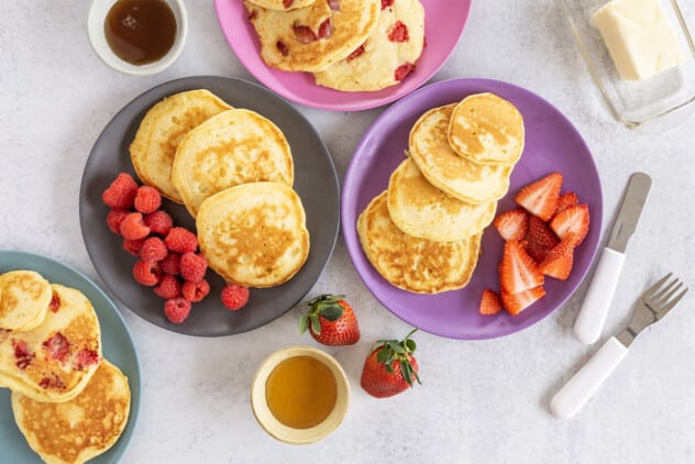 Greek yogurt pancakes on various plates with sides.
