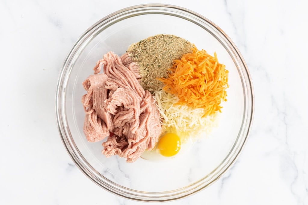 Ingredients for turkey sweet potato meatballs in glass bowl.
