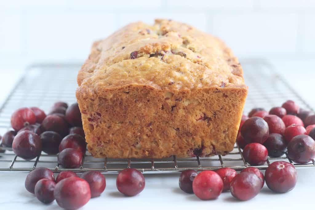 baked cranberry bread loaf on rack.