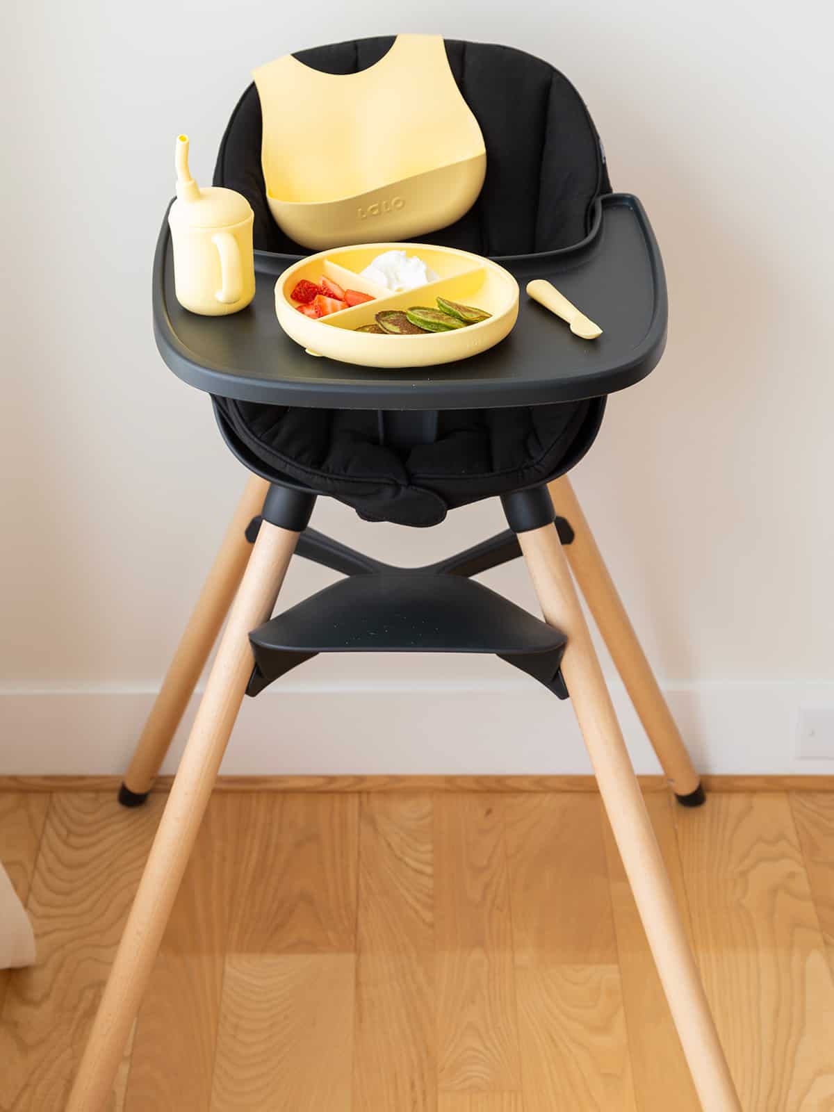 lalo highchair in black with yellow plate of christmas pancakes.