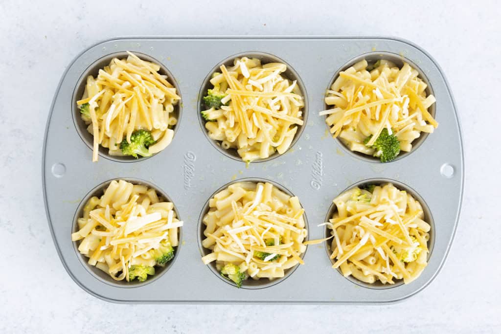 Mac and cheese bites in muffin pan before baking.