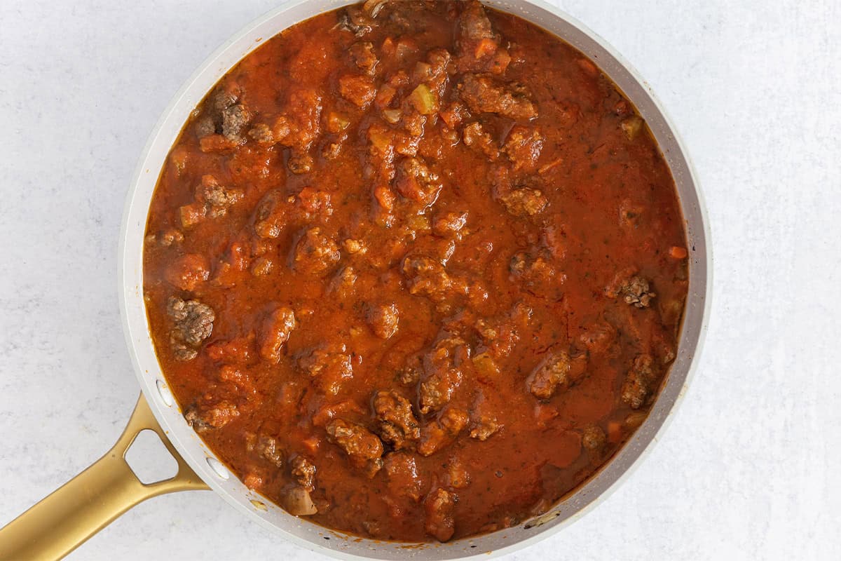 Tomato sauce added to ground beef in pan for ground beef pasta.