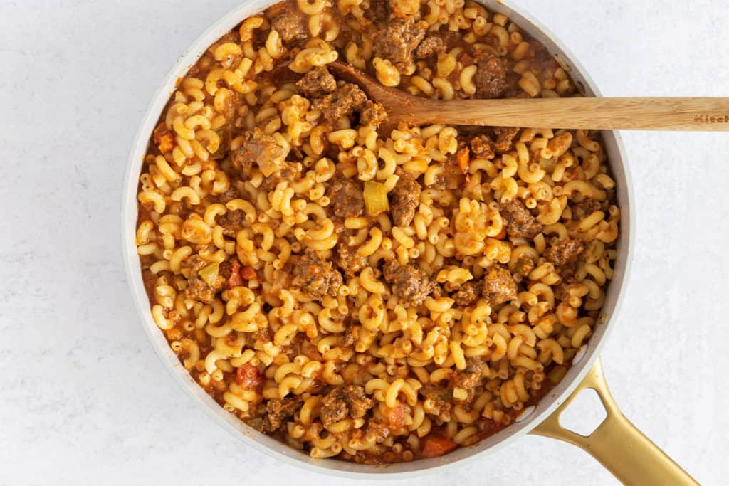 Ground beef pasta in pan with spoon.
