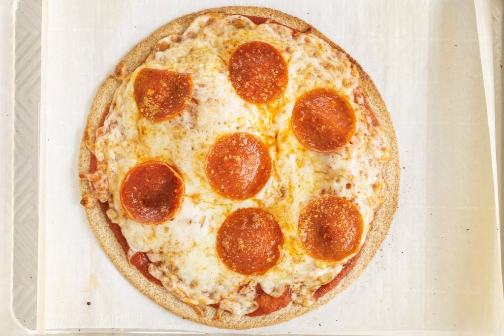 Tortilla pizza on baking sheet after baking.