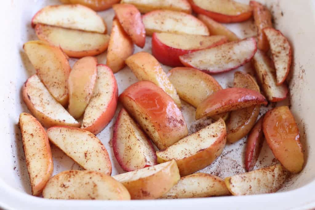 Sliced baked apples in pan after baking.