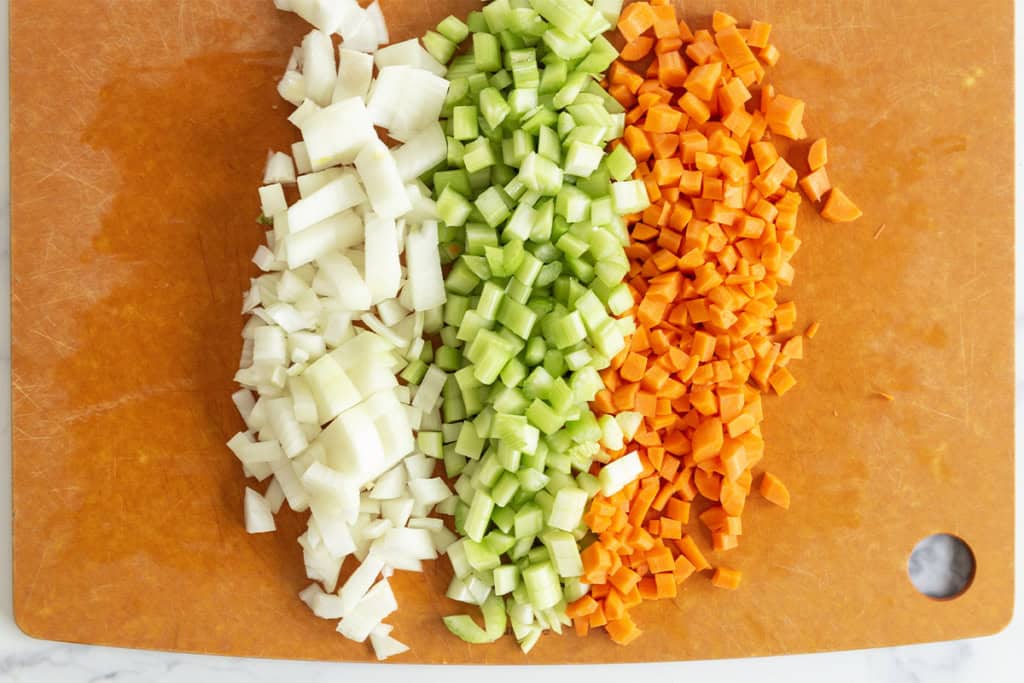 Chopped veggies on cutting board for mirepoix.