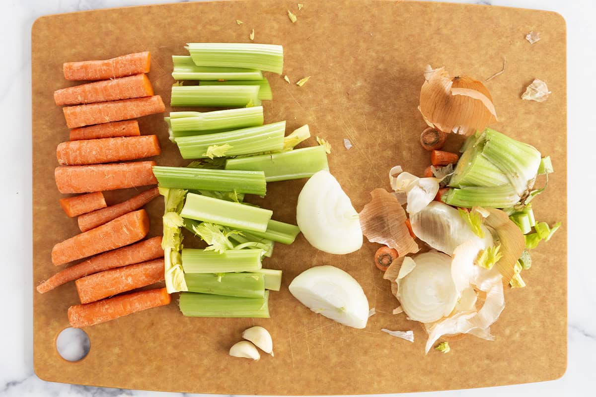 Chopping veggies on cutting board for veggie broth. 