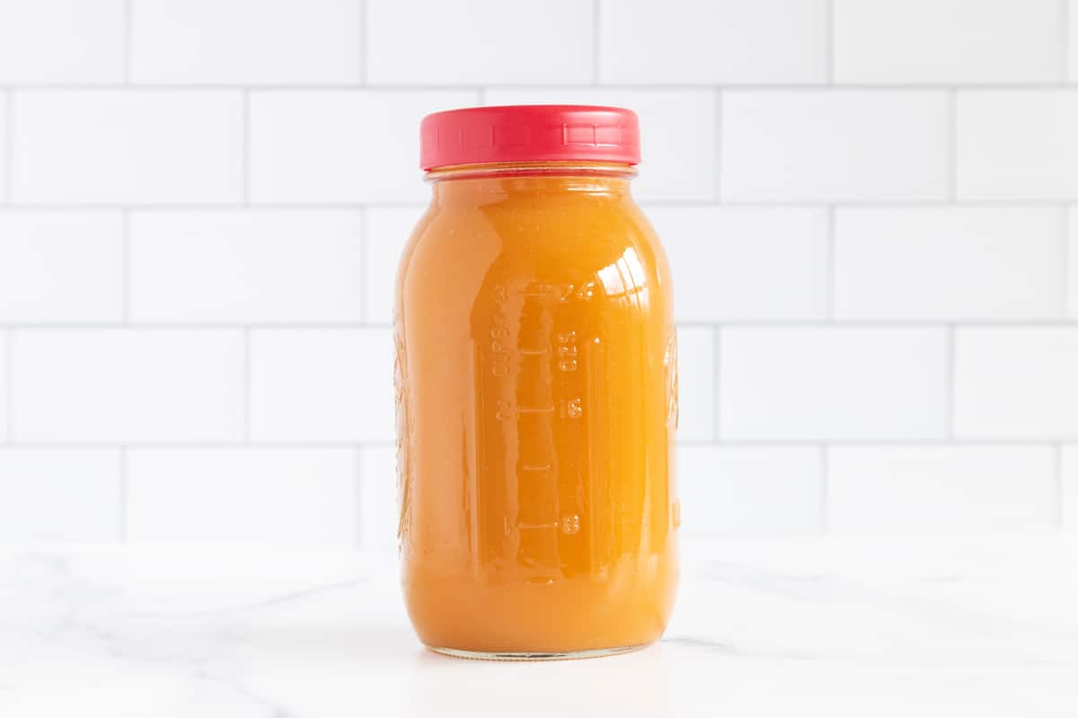Vegetable broth in glass jar with lid.