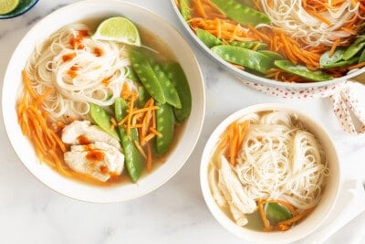 Rice noodle soup in two bowls and pot.