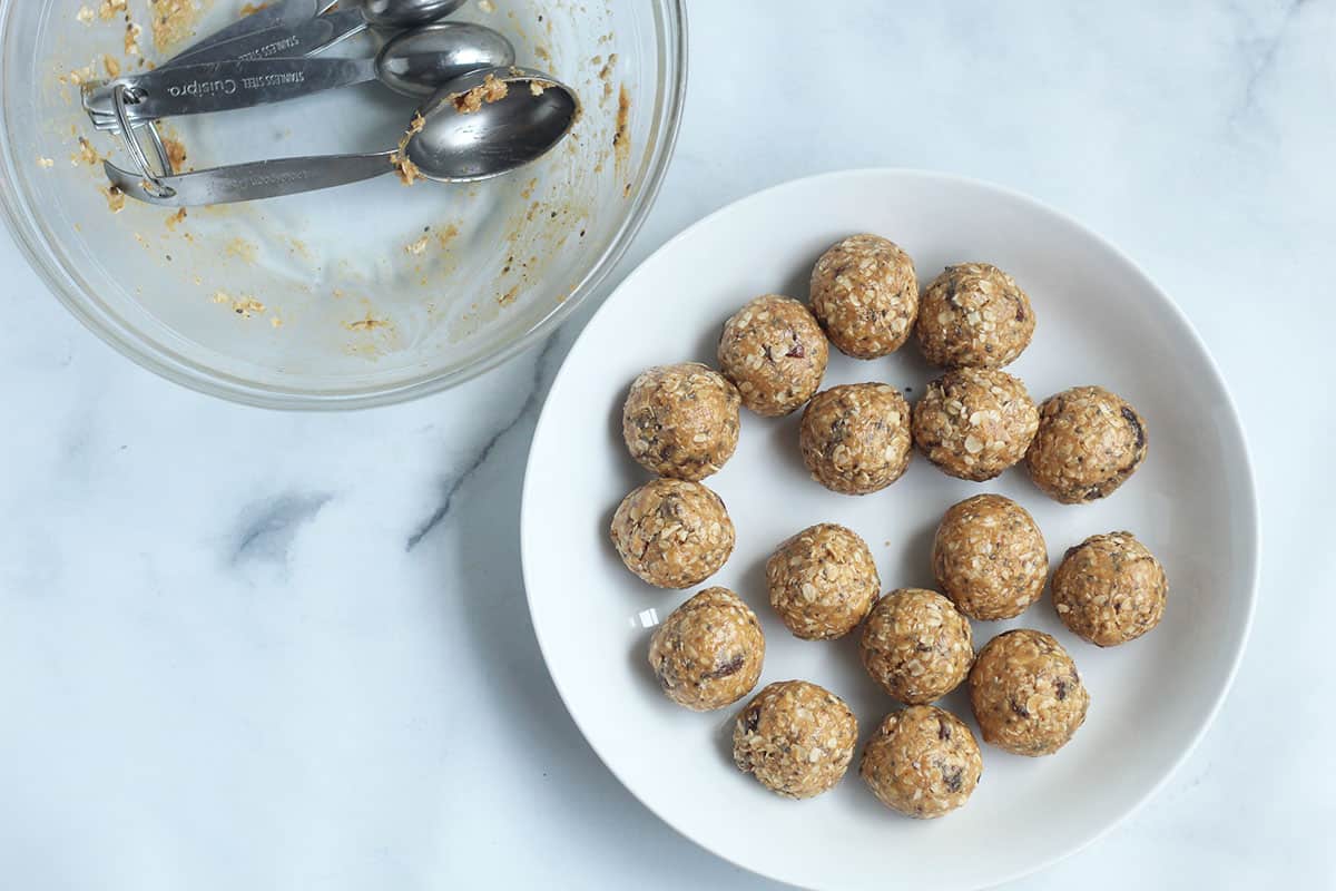 portioned energy bites in white bowl.