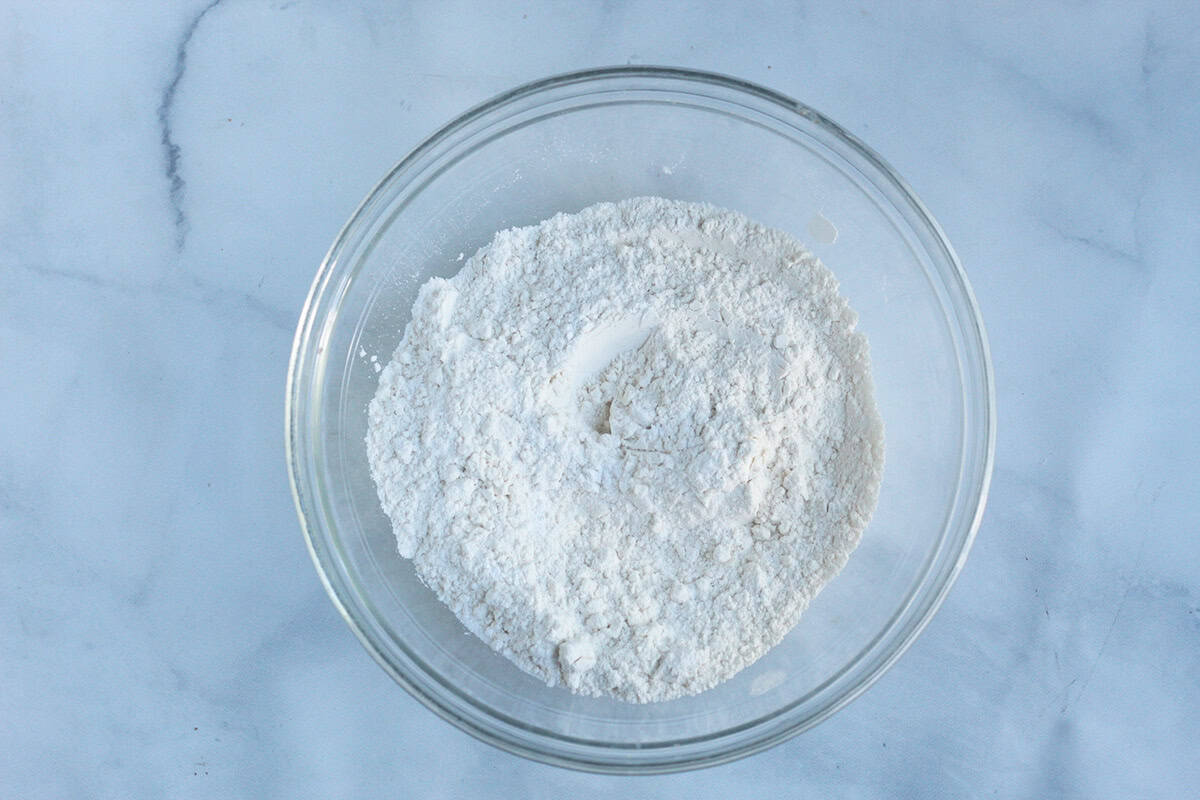 whisking dry ingredients for yogurt pancakes in glass bowl.