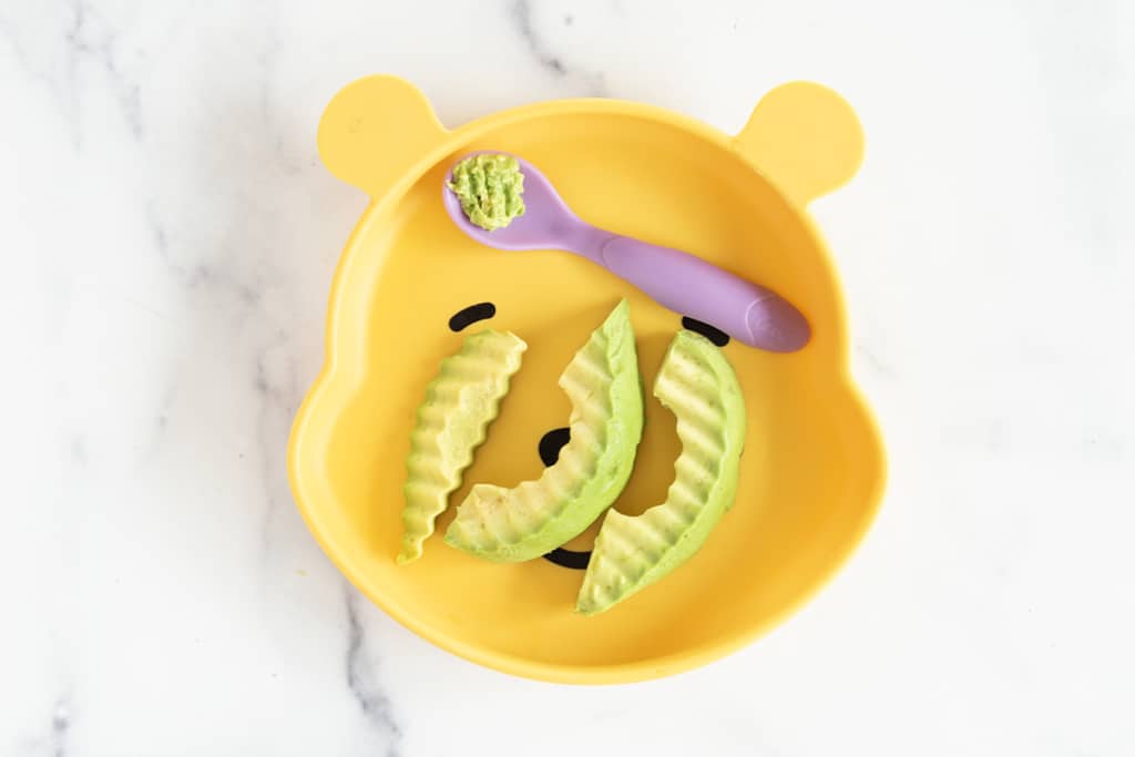 Avocado for BLW on yellow kids plate.