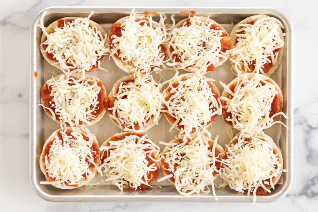 Making bagel pizzas on sheet pan.