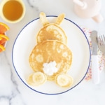 Bunny pancakes on plate with orange slices as side.