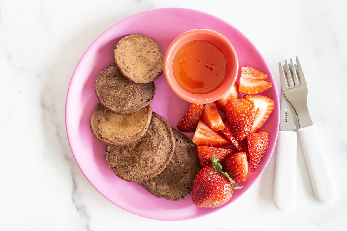 chocolate pancakes on pink plate.