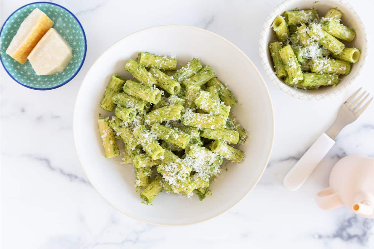 avocado pesto pasta in two bowls with cheese. 