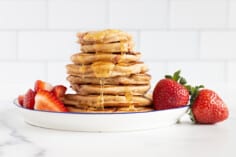 Stack of strawberry pancakes with syrup.