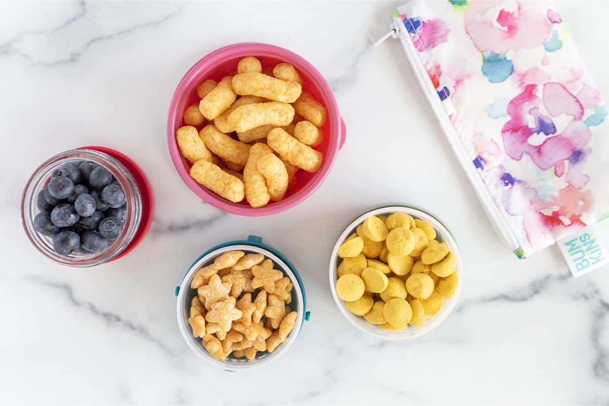 Toddler snack cups filled with various snacks.