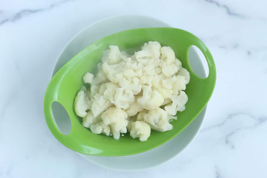 Cauliflower in strainer for cauliflower mac and cheese.