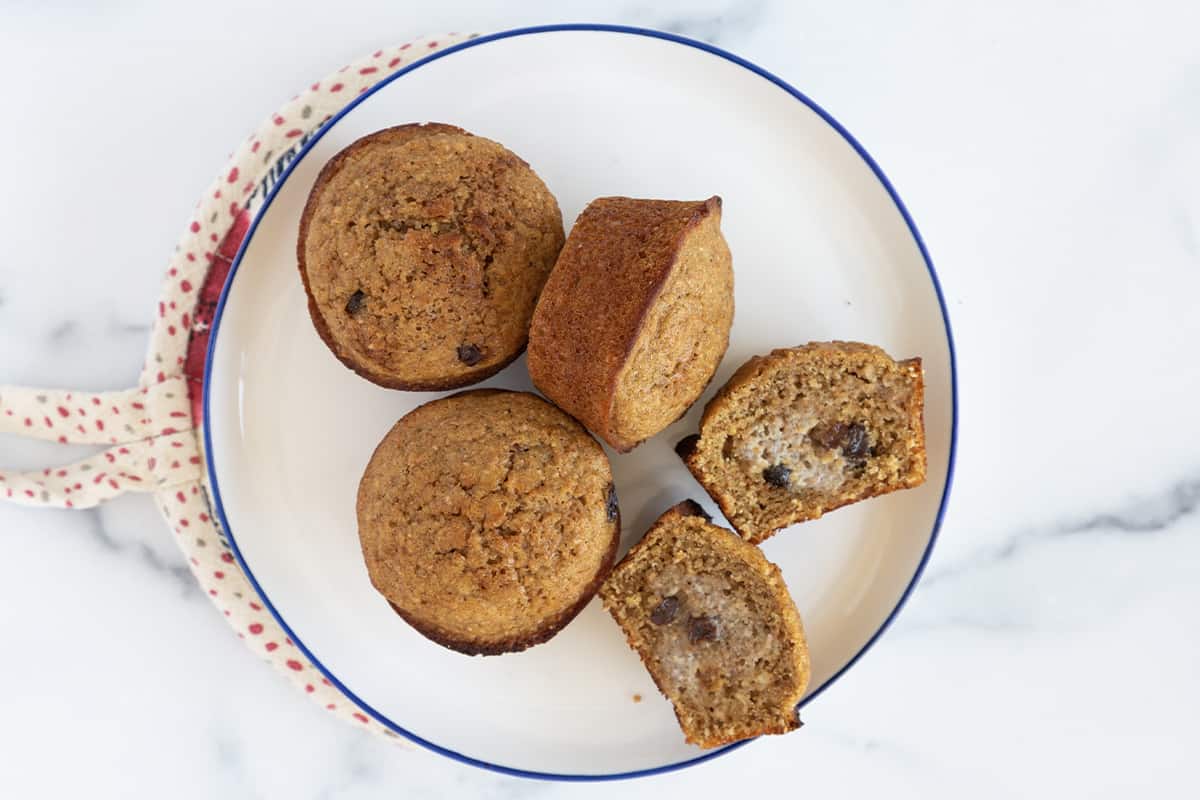 Bran muffins on plate with one cut in half.