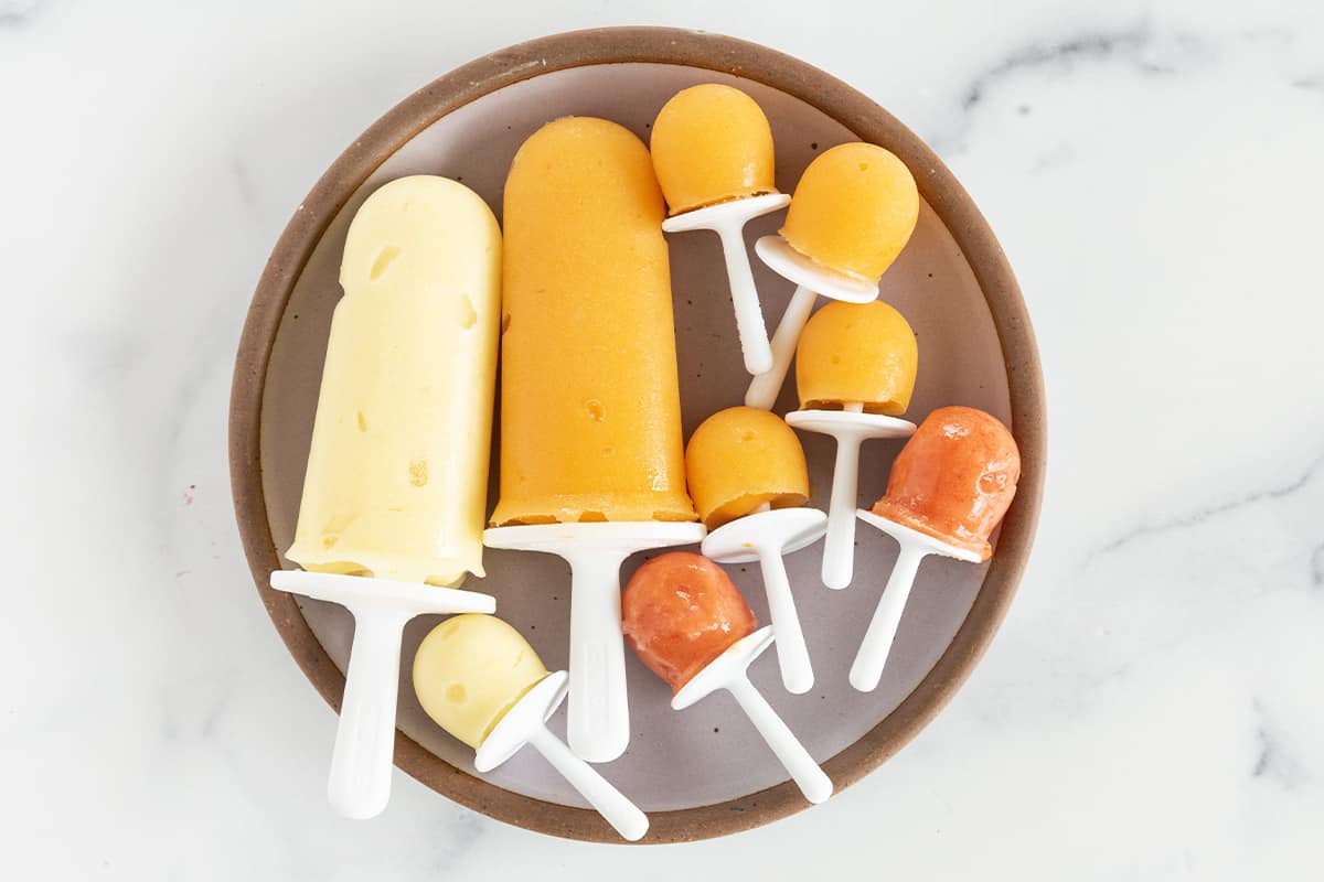 Fruit popsicles on grey plate.