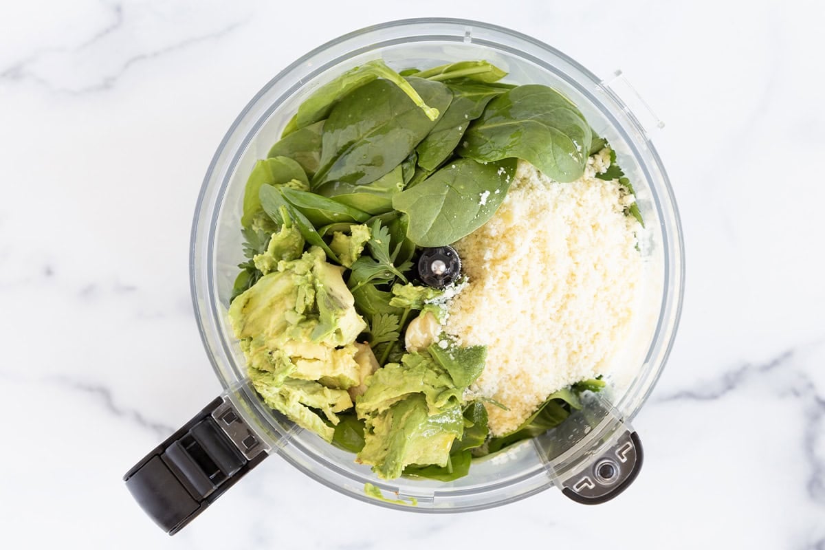 Ingredients for avocado pesto in food processor. 