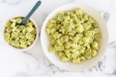 Green pasta sauce pasta in two bowls.