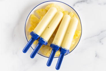 Pineapple popsicles on plate with pineapple.