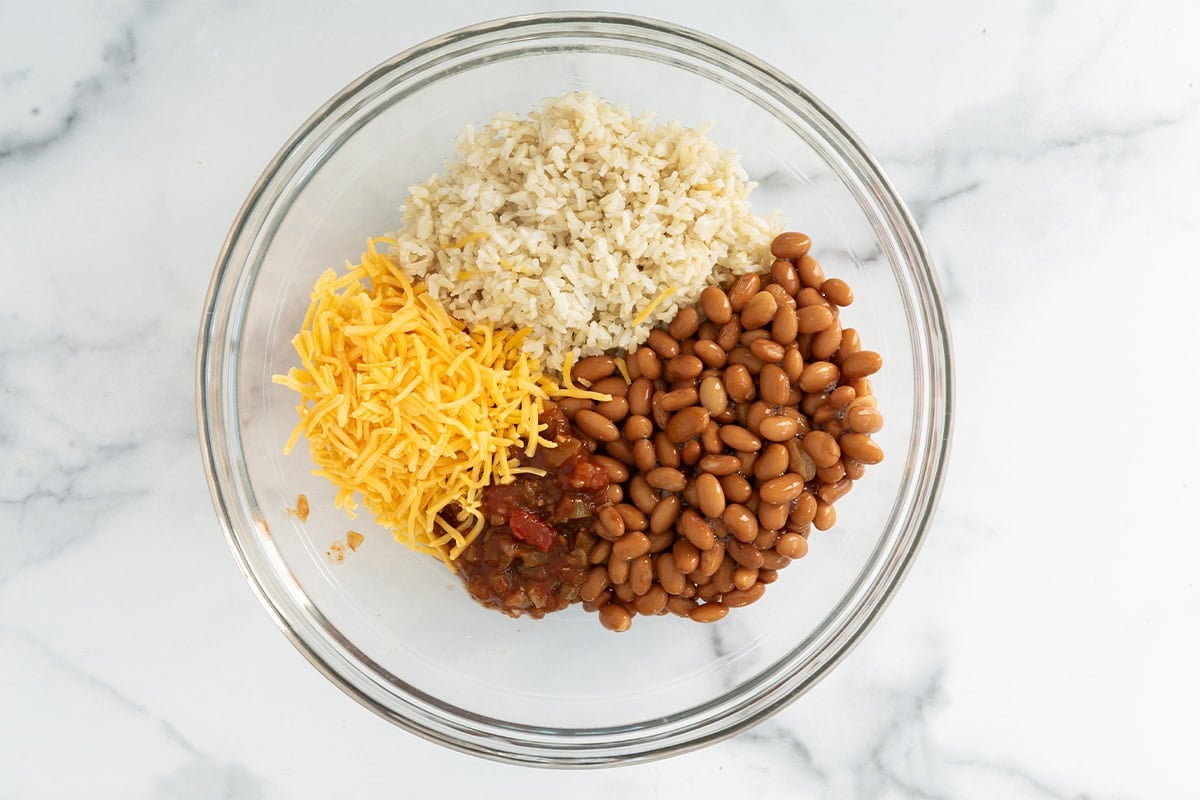 Rice and bean burrito ingredients in glass bowl.