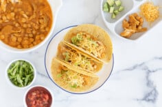 Slow cooker chicken tacos on plate with sides.