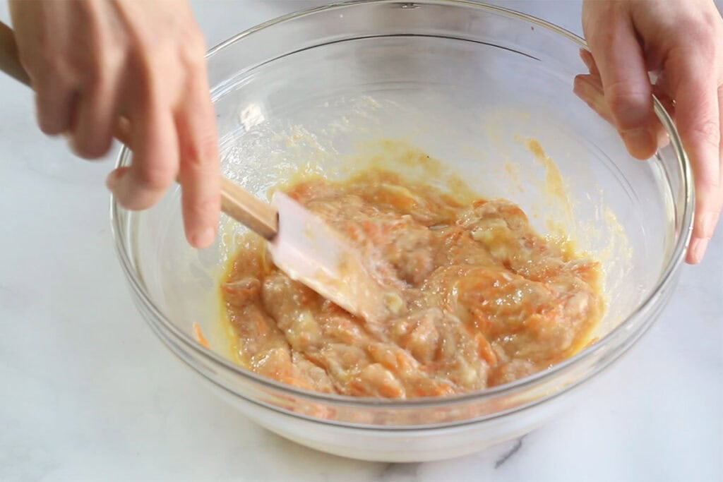 wet ingredients for carrot pancakes in glass bowl.