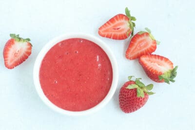 strawberry puree in white bowl with berries.