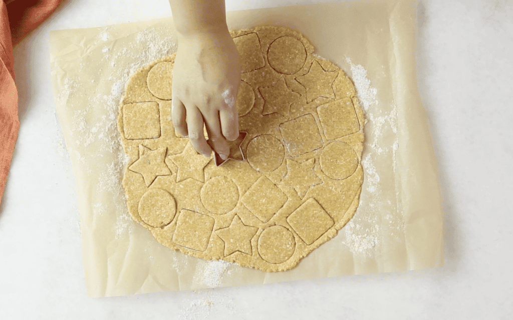 Cutting out the cheese crackers with a cookie cutter. 