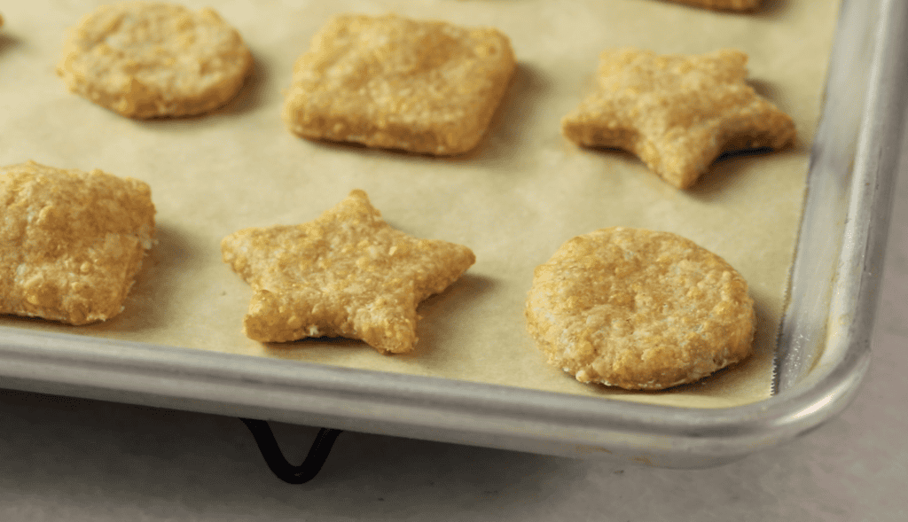 Close up of cheese crackers on baking sheet. 