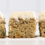 Zucchini cake cut into squares close up from the side.