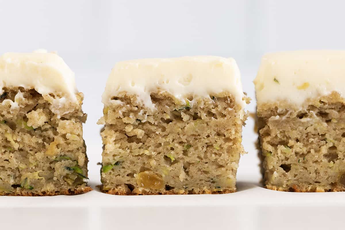 Zucchini cake cut into squares close up from the side.