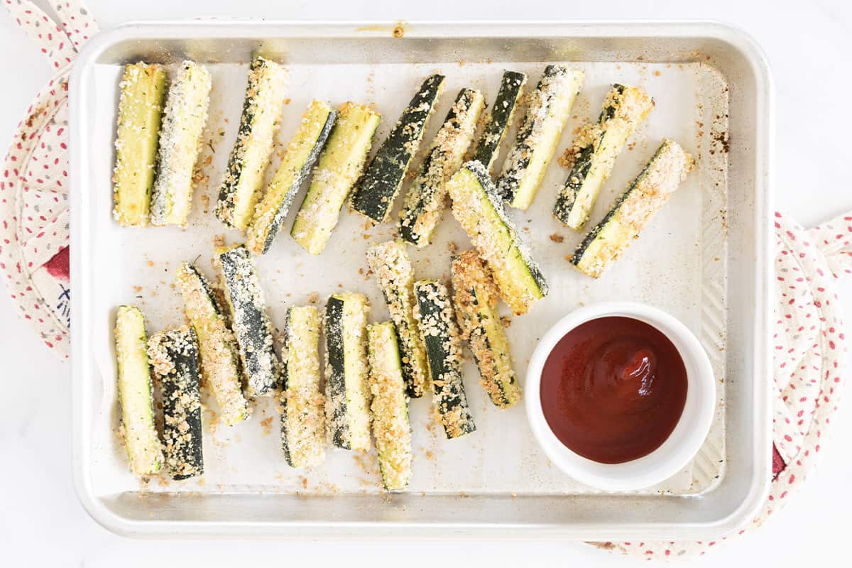 Zucchini fries on pan with ketchup. 